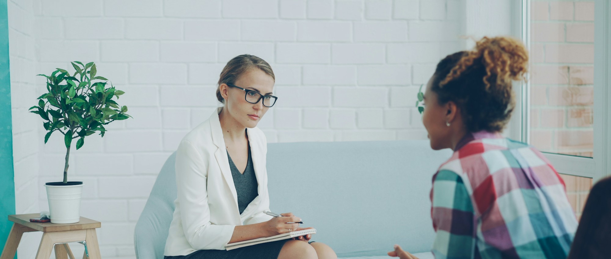 Clinician taking notes during a consultation with a patient